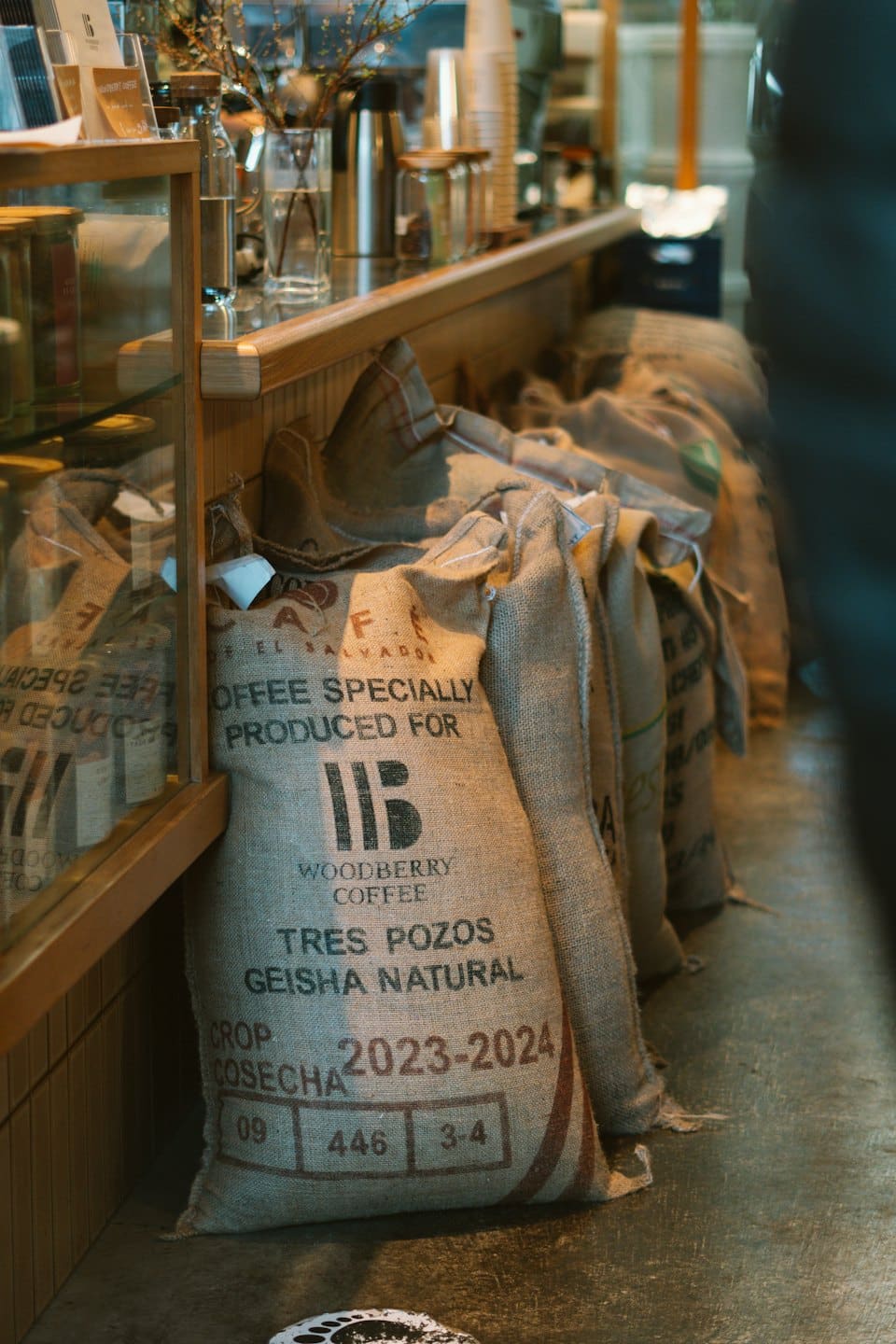 Burlap sacks of coffee beans rest on a shop floor.